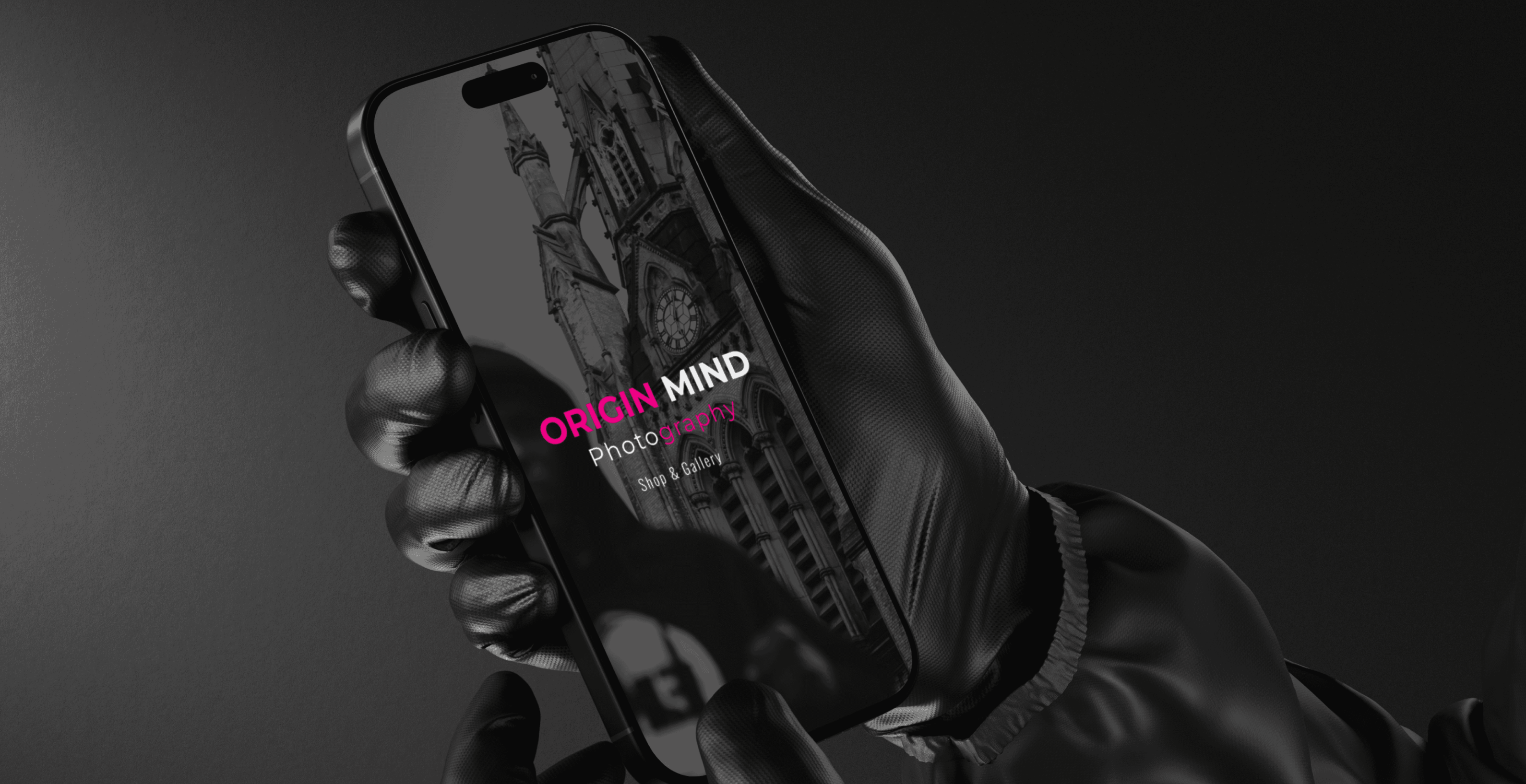 a pair of hands wearing black gloves, holding an iphone face up
